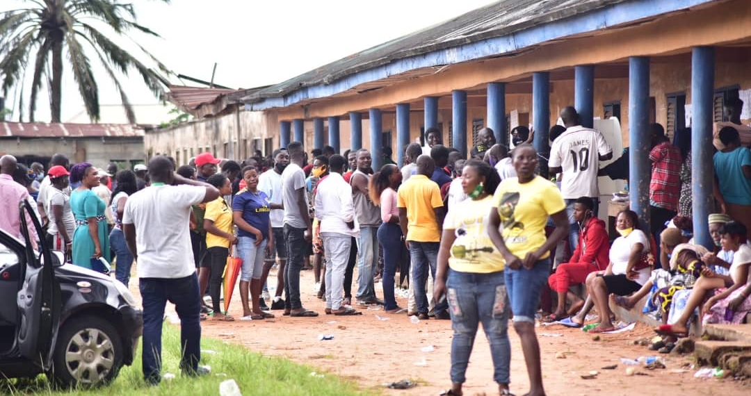 People standing on a queue moving towards the voting cubicle