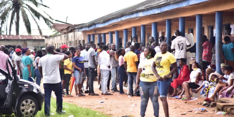 People standing on a queue moving towards the voting cubicle
