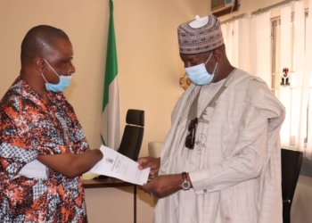 A male amputee presenting a letter to a man, both men facing each other