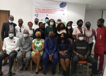 Picture of people sitting and standing in a group photograph and a banner behind them