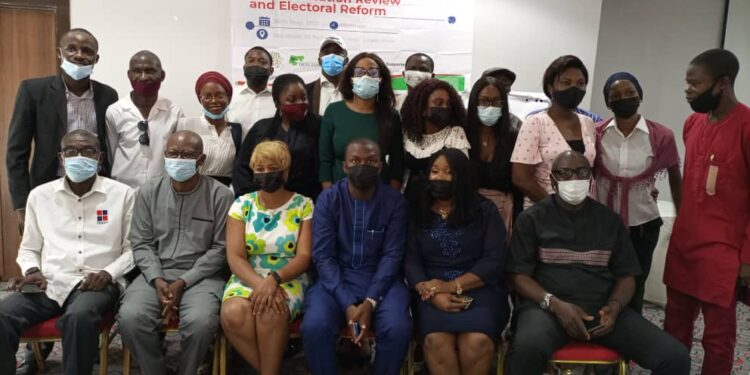 Picture of people sitting and standing in a group photograph and a banner behind them