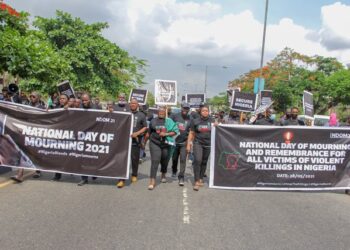 Protesters walking on the road holding placards and banner, complaining about insecurity in Nigeria