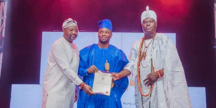 Rasak Adekoya in a group photograph with the ooni of Ife and the minister of youth and sport Sunday Dare during the award presentation.