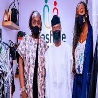 kemi Adeosun, Vice President, Prof. Yemi Osinbajo, and one other person standing to take a photograph at the launching of her store for grassroots charities "Dash Me Store"