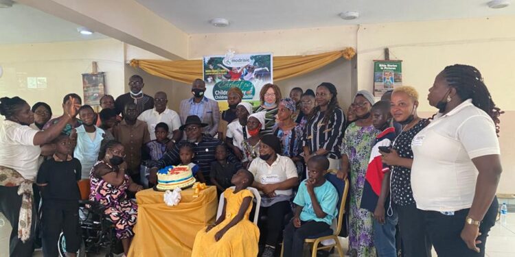 group photograph, some seated while some stood. There is a cake on a table in front of them