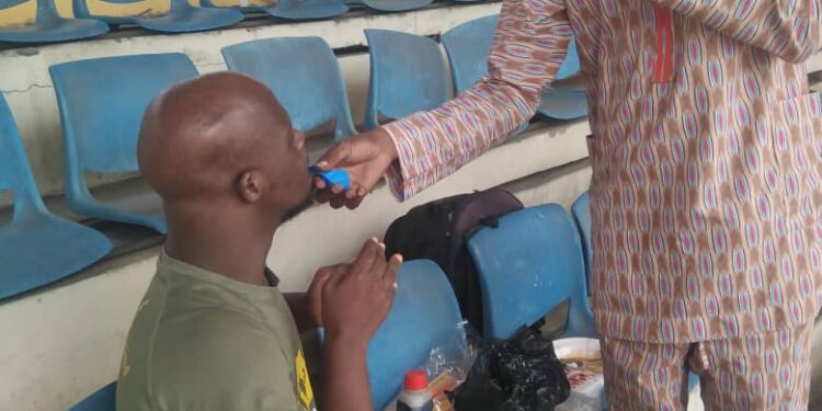 A man standing and another is seating, the man standing is doing an illustration with his hand