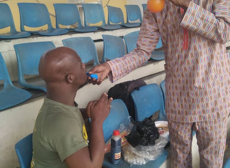 A man standing and another is seating, the man standing is doing an illustration with his hand