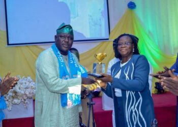 Man presenting an award to a woman, both are standing