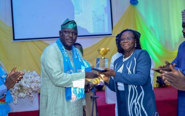 Man presenting an award to a woman, both are standing