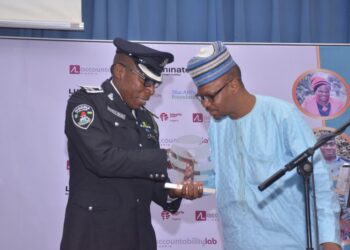 A man giving an award to a police officer
