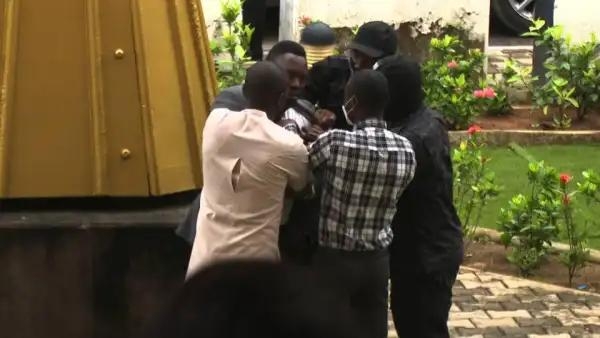 Men gathered seem like they are trying to settle a fight