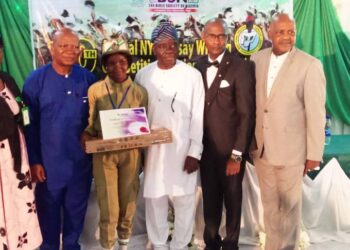 Image showing the presentation of award to Akhibi, as the winner of the essay competition