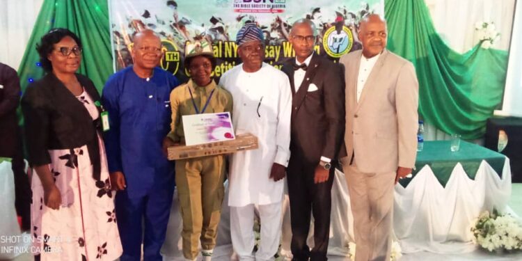 Image showing the presentation of award to Akhibi, as the winner of the essay competition