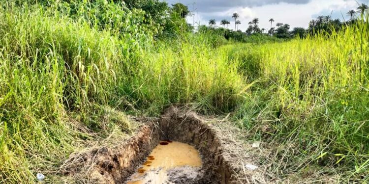 A dredged portion of the ground with oil spill reflecting