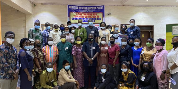 People in a group picture, with the banner describing the event at the background