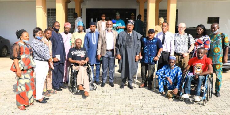 People in group picture, some are standing while the wheelchair users are seated in front
