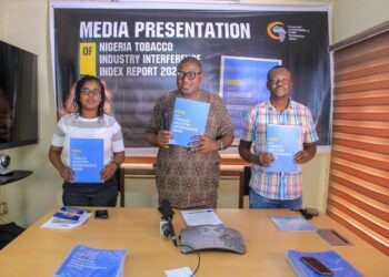 Three people in a picture holding the publication