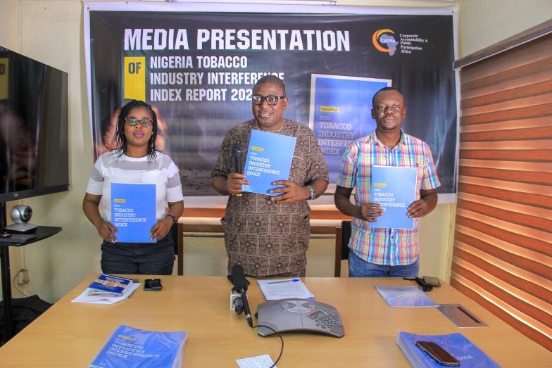 Three people in a picture holding the publication
