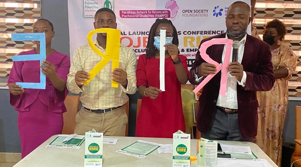 People standing in a group picture and holding cardboards spelling RIRE