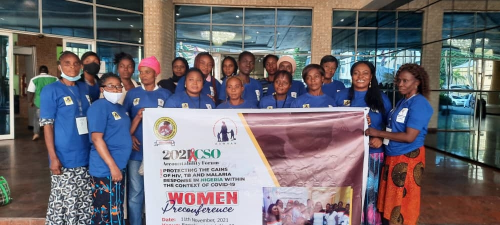 Women in a group picture, holding a banner