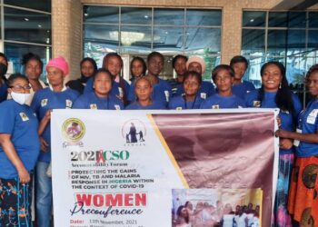 Women in a group picture, holding a banner