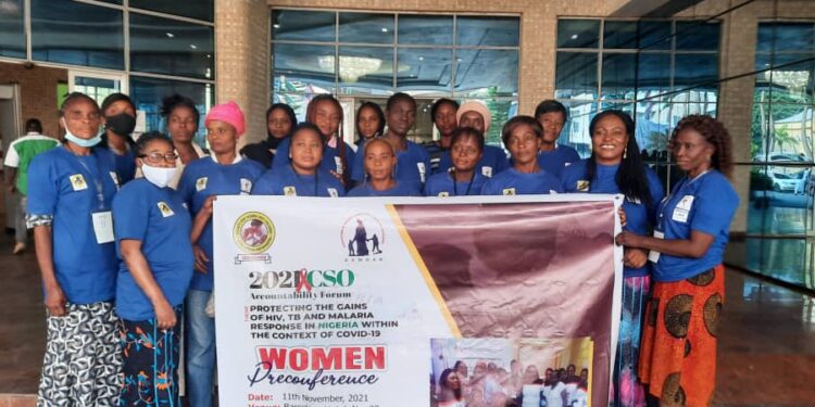 Women in a group picture, holding a banner