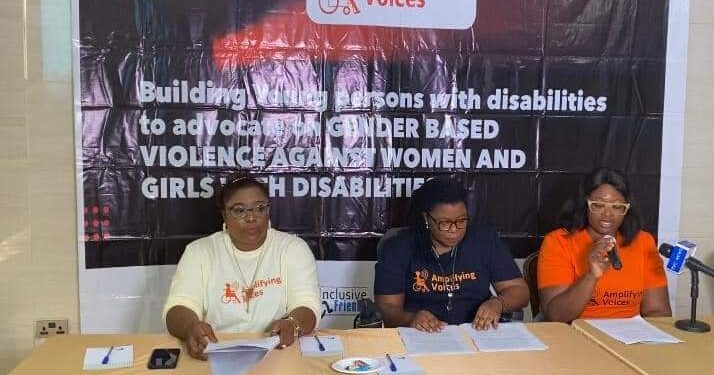 three people seated and one of them holding a microphone