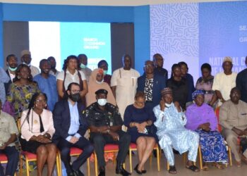 Image of a group of people (man and women) indoors. Some are standing and others are sitting down