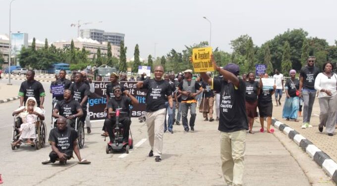 People on the road doing an advocacy walk, most of them are PWDs and are carrying placards