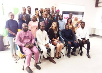 Participants at the event some are seated and others are standing in a well lit room