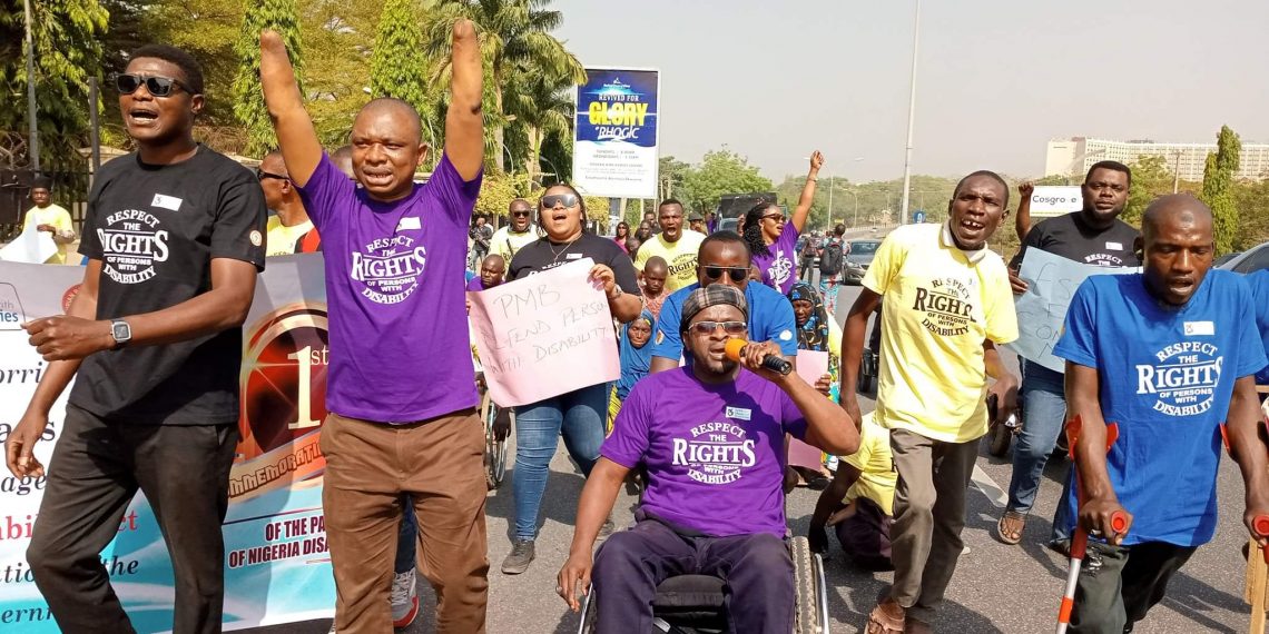 People outdoor on a road walking carrying placards