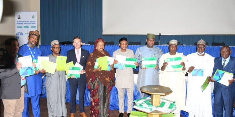 Ten people (nine men and one woman) standing indoor with a book in their hand