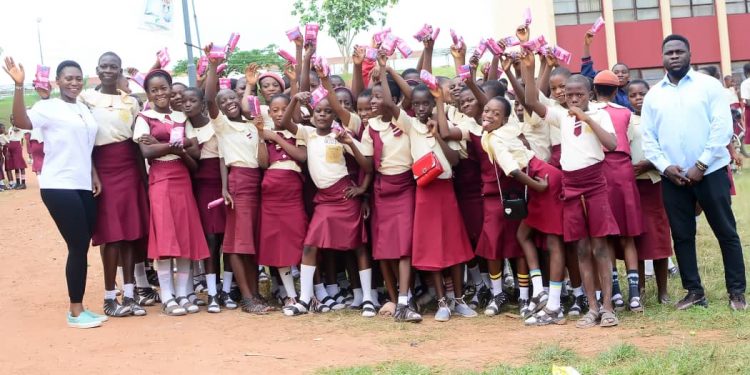 Group of school girls standing close together out door in a cheerful pose
