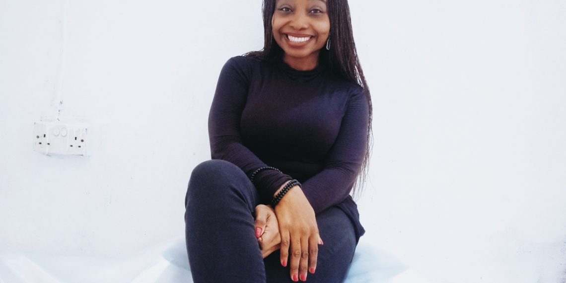 A woman sitting with her legs crossed, wearing black