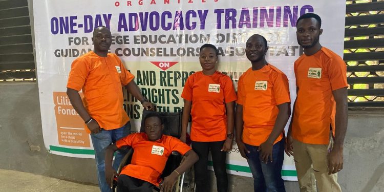 People in a group picture, one person is on a wheelchair and the dominant colour is orange