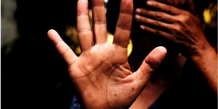 A female stretched out hand with the palm open and fingers spread out in a resistive manner