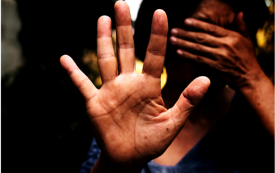 A female stretched out hand with the palm open and fingers spread out in a resistive manner