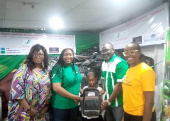Four adults and a child with a bag standing indoor