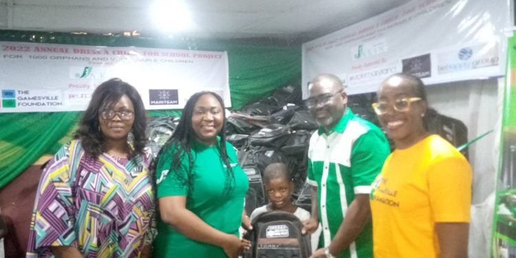 Four adults and a child with a bag standing indoor