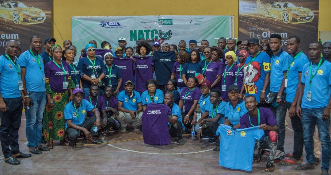 Image of many men and women, some standing and some squatting indoor