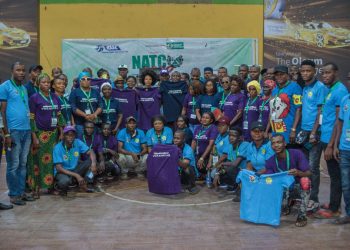 Image of many men and women, some standing and some squatting indoor