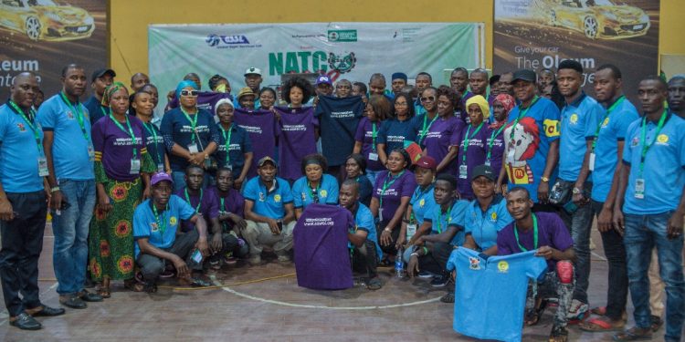Image of many men and women, some standing and some squatting indoor
