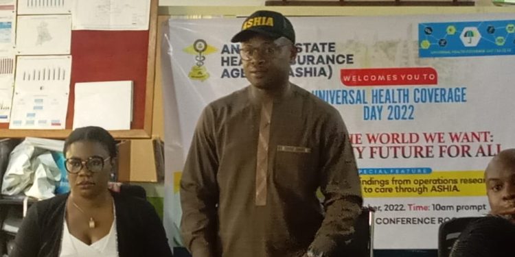 A man standing indoor with a cap on his head