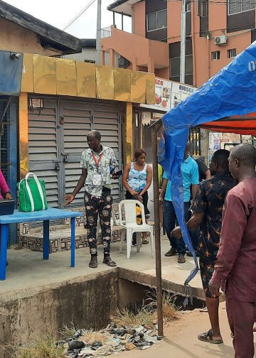 INEC officials setting up the ballot boxes across the gutter in PU 079, Ajayi Road, Ojodu LCDA, Ikeja LGA, Lagos during the 2023 Presidential and NASS elections.
