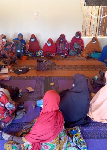 Women holding their monthly Village Savings and Loan Association (VSLA) meeting at Shuwari Lambu Safe Space