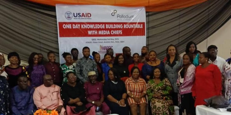 People in a group picture, there is a banner at the background