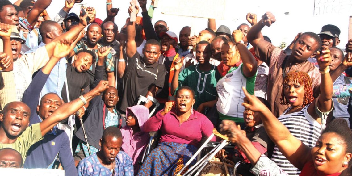 People outdoor gathered. They have their fist up