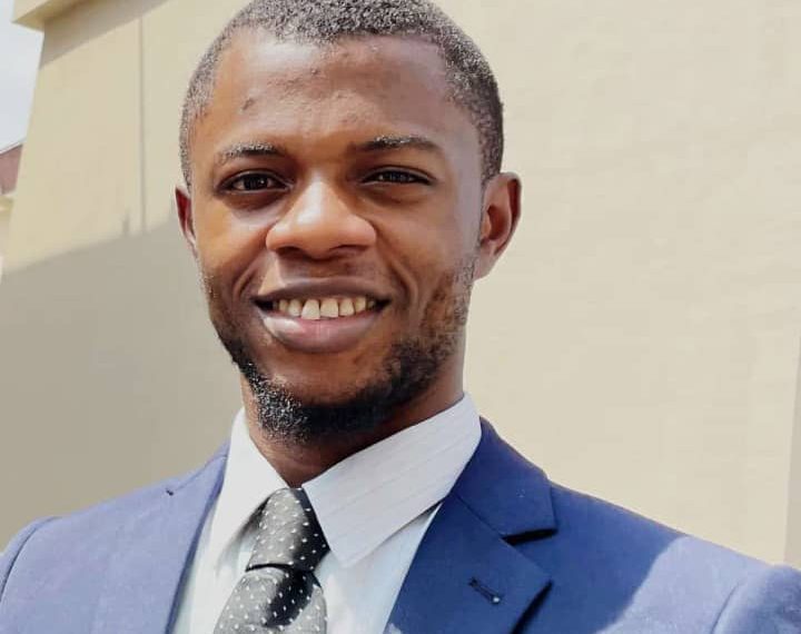 A man in a passport photo wearing a tie