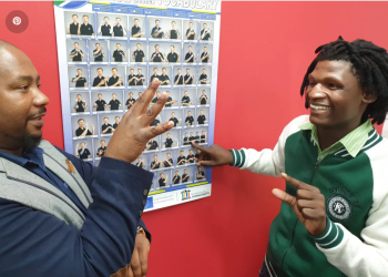 Two men making gestures with their hands indoor