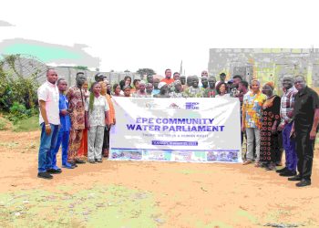 A group of people standing outdoor with a banner